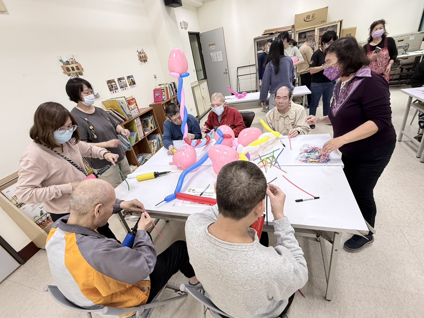 服務對象與教保員合力完成氣球造型，畫面充滿專注與互動